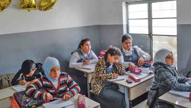 Iraq: at a glance Girls sit at desks in a classroom